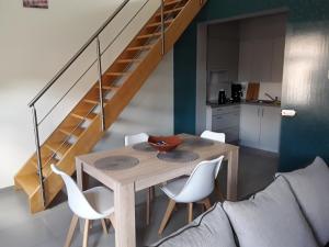 stół jadalny z białymi krzesłami i schody w obiekcie Discover w mieście Ypres