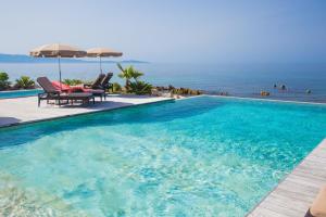 a swimming pool with a view of the ocean at Hôtel Le Week end in Ajaccio