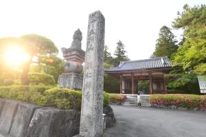 a pole with writing on it in front of a pagoda at 乳幼児不可12歳から可丸ごと貸切りではない部屋の素泊まり静かな方無料WiFi in Irumagawa