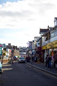 a busy city street with people walking on the sidewalk at The Pad in Newquay