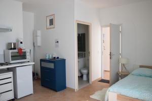 een kleine slaapkamer met een blauwe dressoir en een badkamer bij Joli Studio Plein Centre de Milly la Forêt in Milly-la-Forêt
