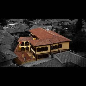 a large house with a red roof in a city at Anemon Hotel Kula in Kula