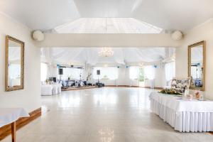 a large banquet hall with white tables and mirrors at Hotel Sezam in Machowa