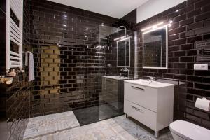 マドリードにあるSerrano Comfort, by Presidence Rentalsの黒いタイル張りのバスルーム(シンク、シャワー付)