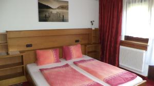 een slaapkamer met een bed met roze kussens bij Gästehaus Tramnitz in Mayrhofen