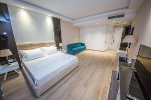 a large bedroom with a bed and a blue couch at Sole Luna Hotel in Borsh