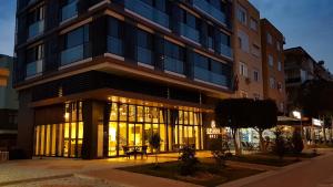 a building with a lit up facade at night at Ozyigit Otel in Gazipasa