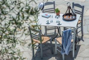 a table with two chairs and a lamp on it at Mirabilia Boutique Hotel in Kriopigi