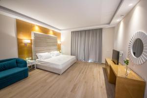 a hotel room with a bed and a blue couch at Sole Luna Hotel in Borsh