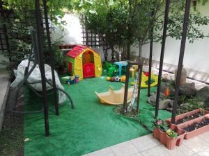a childrens play area with a playground in a garden at Pensiunea La Dolce Vita in Băile Herculane