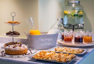a table topped with plates of pastries and drinks at Mirabilia Boutique Hotel in Kriopigi