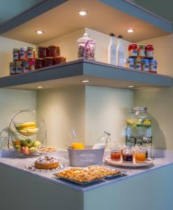 a buffet with food and drinks on a shelf at Mirabilia Boutique Hotel in Kriopigi