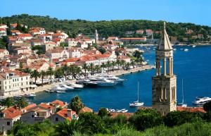 a town with boats in the water and a clock tower at King's Landing - Hvar in Hvar