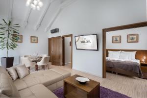 a living room with a couch and a bed and a table at Botrytis Borhotel in Mád