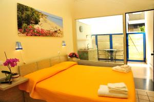 a bedroom with a yellow bed and a window at Cala Dei Normanni - Camere sul Lungomare in Otranto
