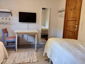 1 dormitorio con escritorio, TV y cama en Dåstrup Bed & Breakfast, en Viby