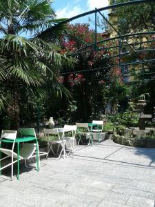 a patio with chairs and tables and flowers at Hotel Malta in Milan