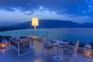 a table and chairs on a balcony with a view at Princess Kyniska Suites in Plytra