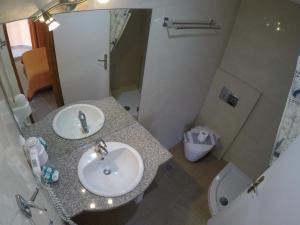a bathroom with two sinks and a shower and a toilet at Kalias Hotel in Vasiliki