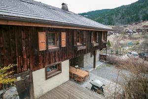 a wooden building with a table and chairs in front of it at Chalet Vogue in Morzine +9 photos