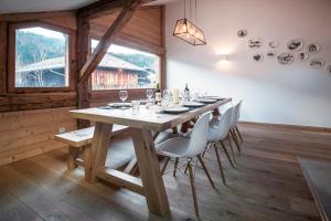 a dining room with a wooden table and chairs at Chalet Vogue in Morzine