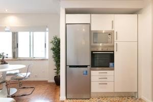 cocina con nevera de acero inoxidable y mesa en Your Lisbon Home - Duque de Palmela en Lisboa