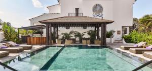 a swimming pool with a gazebo next to a house at Nobu Hotel Marbella in Marbella