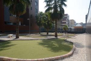 EnjoyGranada EMIR 3F - POOL, GYM & Free Parking في غرناطة: حديقة بها نخيل ومسبح به ماء