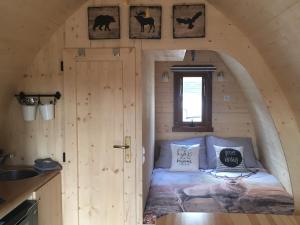 - une petite chambre dans une cabane en rondins avec un lit dans l'établissement De Rozephoeve Studio, à Oisterwijk
