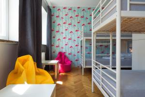 a room with a bed, a chair, and a window at Tatamka Hostel in Warsaw