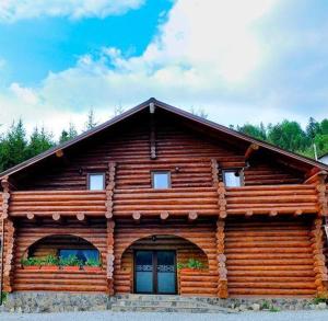 a log cabin with two windows on the front at Hanul Prislop in Statiunea Borsa +8 photos