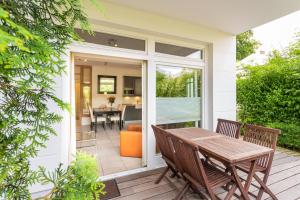 eine abgeschirmte Veranda mit einem Tisch und Stühlen in der Unterkunft strandnahe und moderne FeWo mit Terrasse, Villa Ravensberg, Binz in Binz