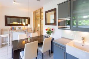 eine Küche mit einem Tisch, Stühlen und einem Waschbecken in der Unterkunft strandnahe und moderne FeWo mit Terrasse, Villa Ravensberg, Binz in Binz