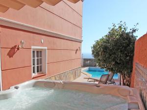 una piscina junto a un edificio con bañera de hidromasaje en ViVaTenerife - Villa with pool, jacuzzi and sea view, en Chayofa