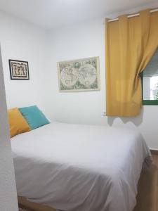 a bedroom with two beds and a yellow curtain at Playa Muchavista lovely ground floor apartment in El Campello