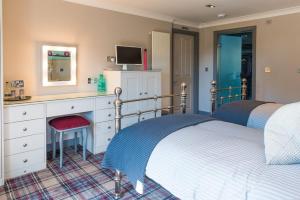a bedroom with two beds and a desk with a mirror at The Sawley Arms in Ripon