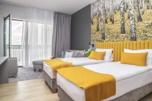 2 camas en una habitación de hotel con un cuadro en la pared en Notera Hotel SPA, en Charzykowy
