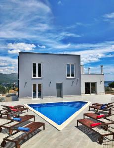 a villa with a swimming pool and lounge chairs at Villa Mila Kastela in Kastel Novi