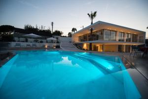 a large swimming pool in front of a house at Capo Torre Resort & SPA in Albisola Superiore