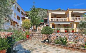 una casa con un muro di pietra e un sentiero in pietra di Niki Apartments a Panormos Skopelos