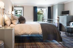 ein Schlafzimmer mit einem großen Bett und einem TV in der Unterkunft The Sawley Arms in Ripon
