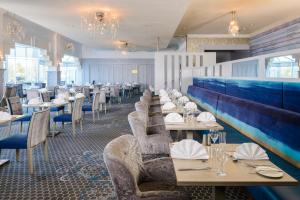 a restaurant with tables and chairs and a blue wall at Hillgrove Hotel, Leisure & Spa in Monaghan