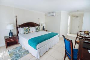 a bedroom with a bed and a table and a desk at Bay Gardens Marina Haven in Gros Islet