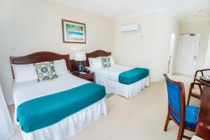 a hotel room with two beds and a chair at Bay Gardens Marina Haven in Gros Islet