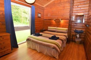 a bedroom with a bed in a log cabin at 18 Lamont Lodges in Dunoon