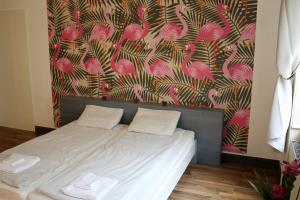 a bedroom with a bed with pink flamingos wallpaper at Pension Wienderland in Vienna