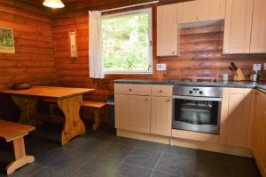 a kitchen with a stove and a table and a window at 18 Lamont Lodges in Dunoon
