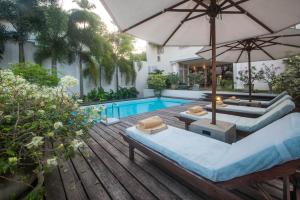 an outdoor patio with a pool and an umbrella at 20 Middle Street in Galle