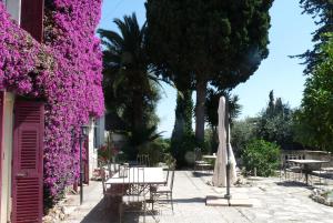 un patio con fiori viola, tavolo e ombrellone di Castel Enchanté a Nizza