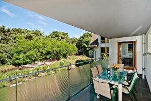 a balcony with a glass table and chairs at BlueApart Nadmorski Park Jastarnia in Jastarnia